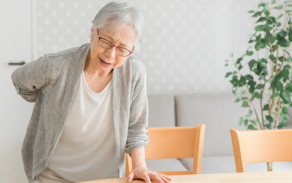 腰をおさえているご年輩女性